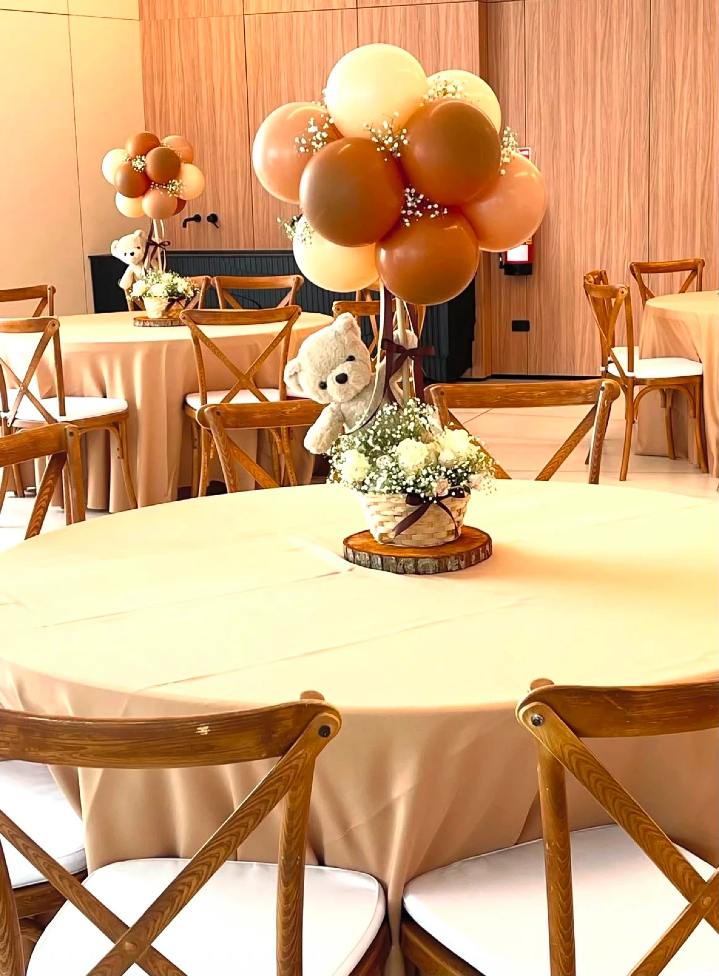 Event setup with elegant wooden chairs, round tables and balloon centerpieces