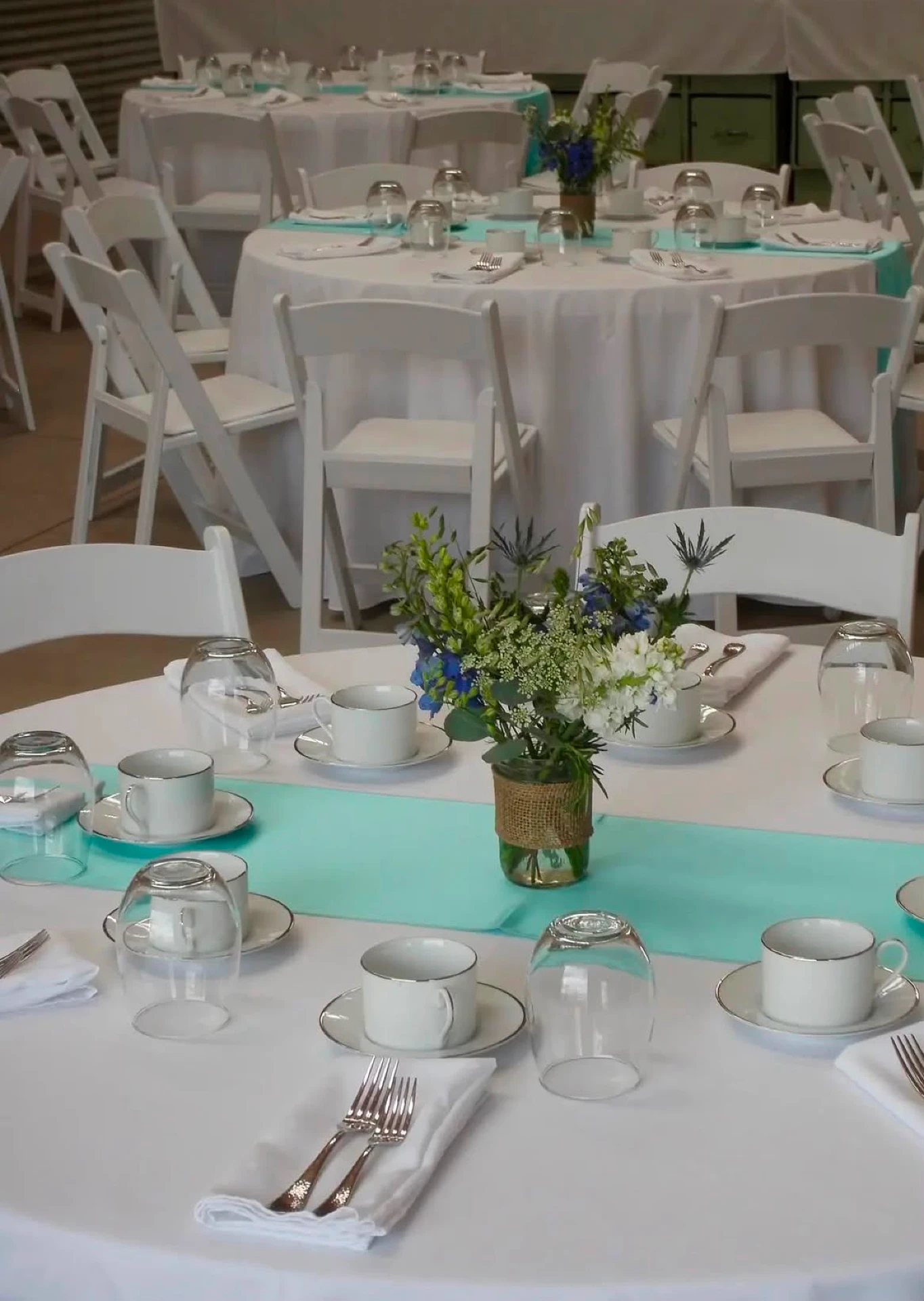 Outdoor tent reception with long banquet tables at sunset