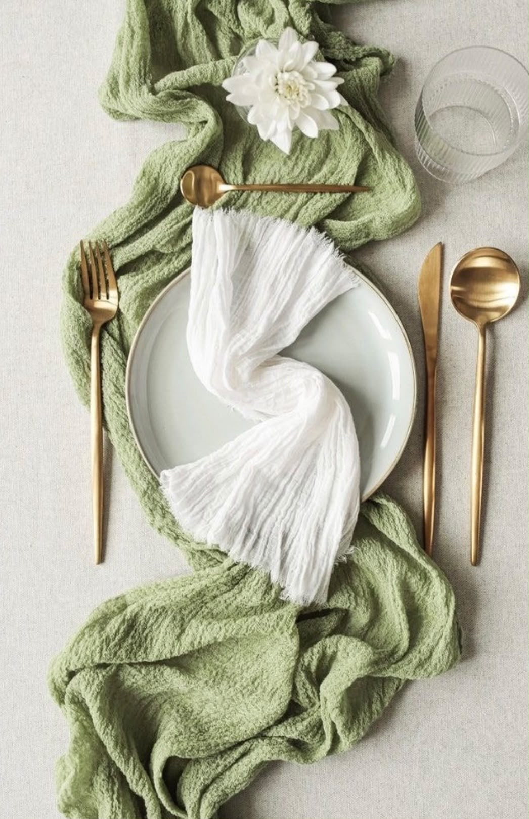 Table setting with white napkin and sage green accents