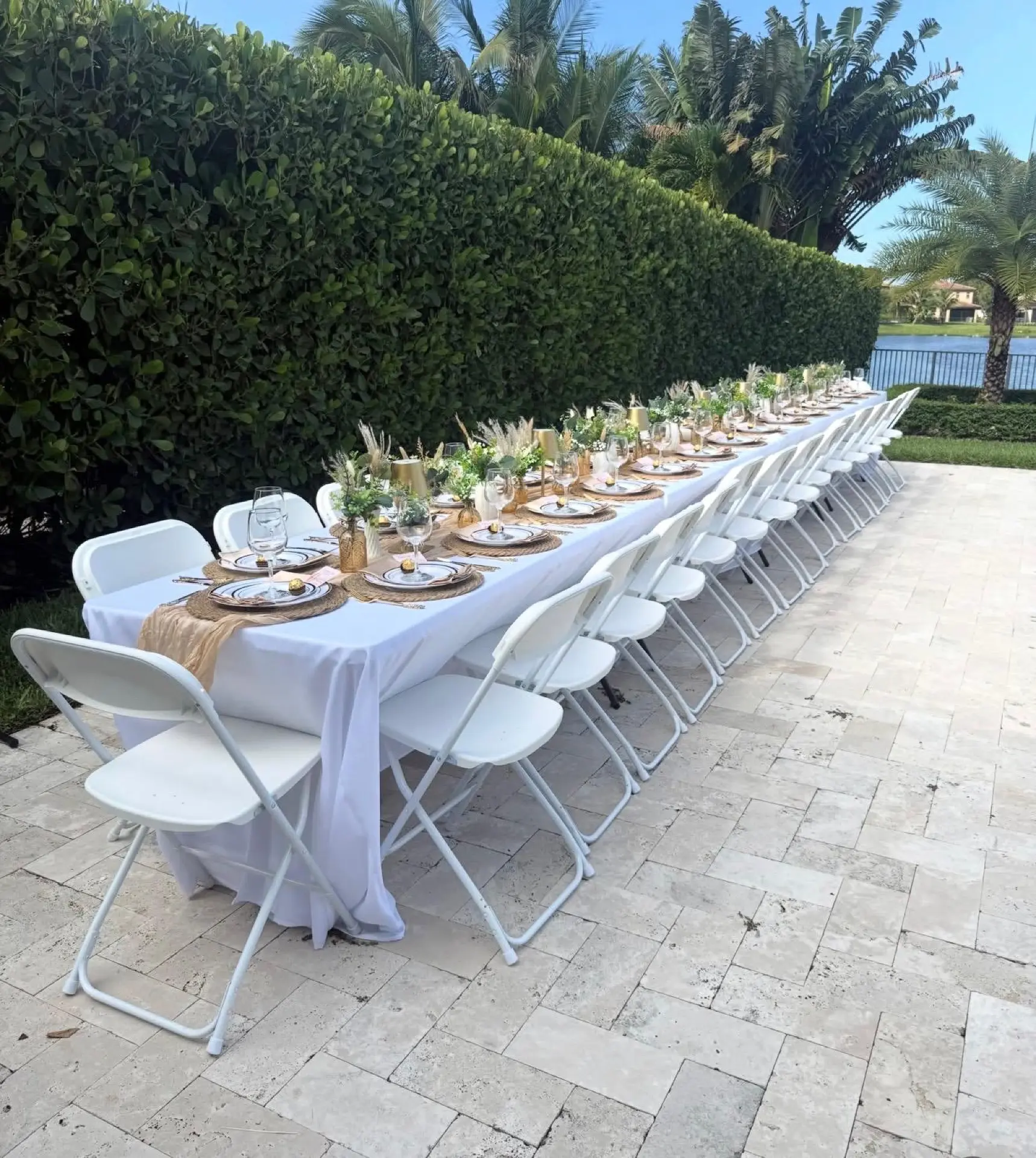 Long outdoor table by the water set for an elegant event
