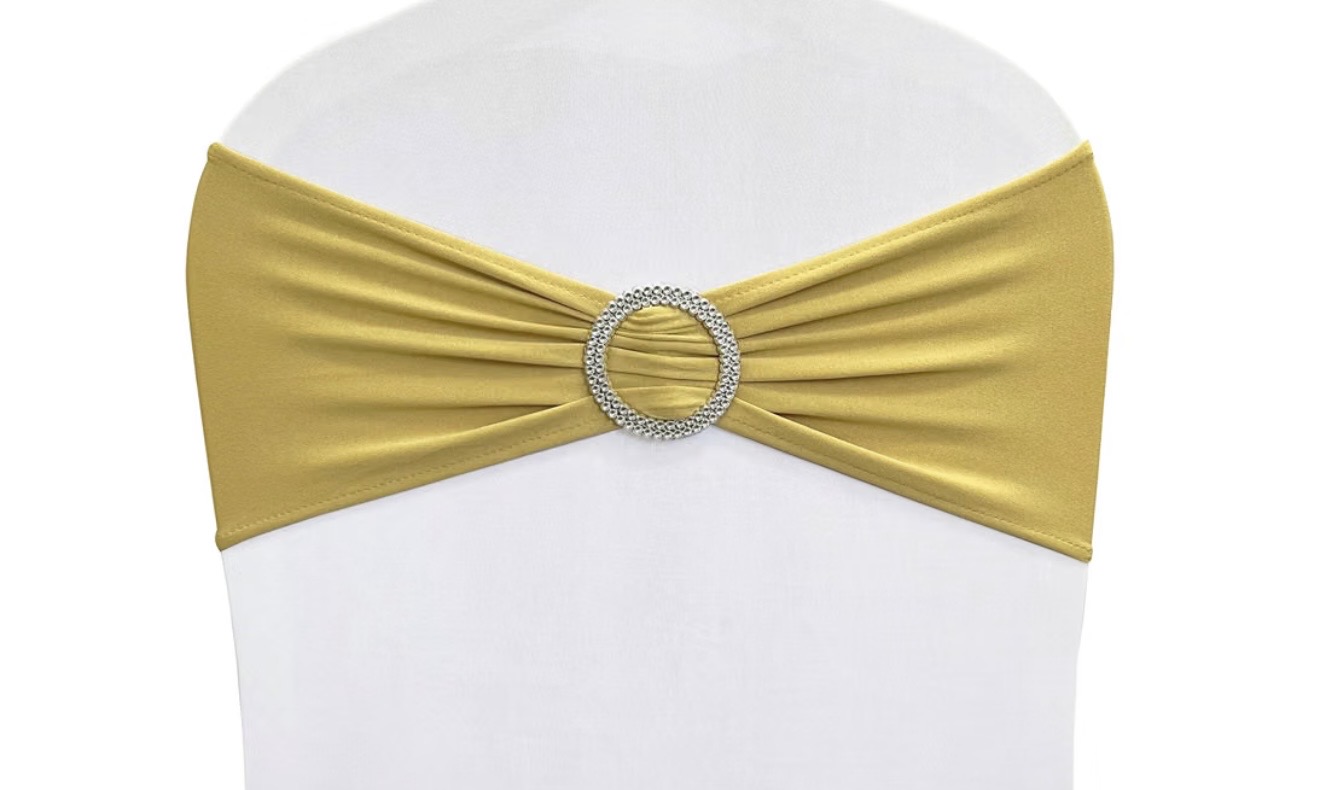 White chair with a gold spandex sash and rhinestone buckle