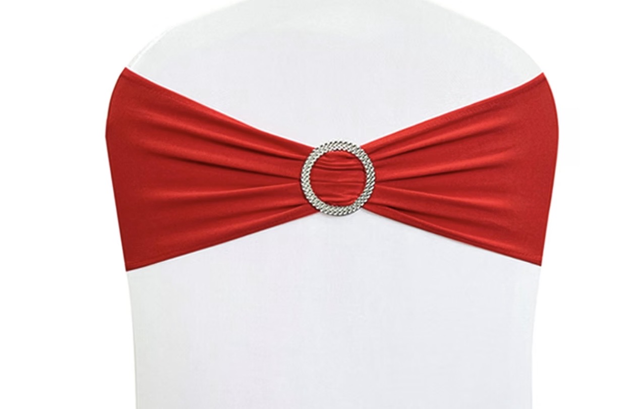 White chair with a red spandex sash and rhinestone buckle