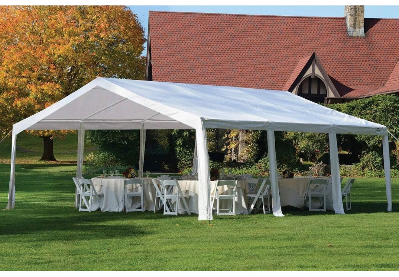 White event tent set up on a green lawn